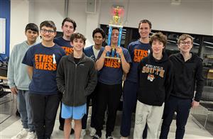 Nine members of the ETHS Chess Team posing with the 1st place trophy from a tournament in Highland Park.